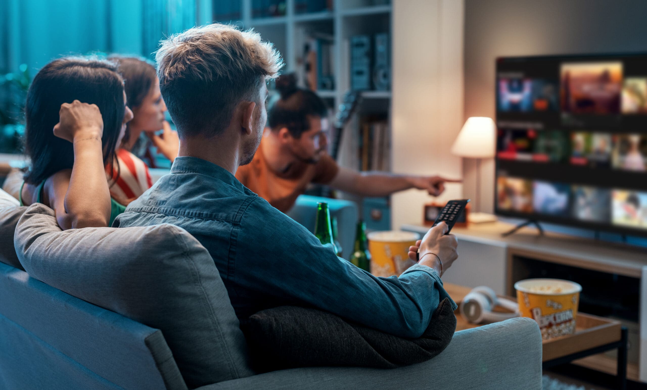 Friends choosing a movie to watch together at home, video on demand concept